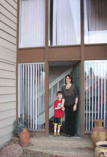 Homeowner Kathy Ellis and her son stand at the entrance of the home.